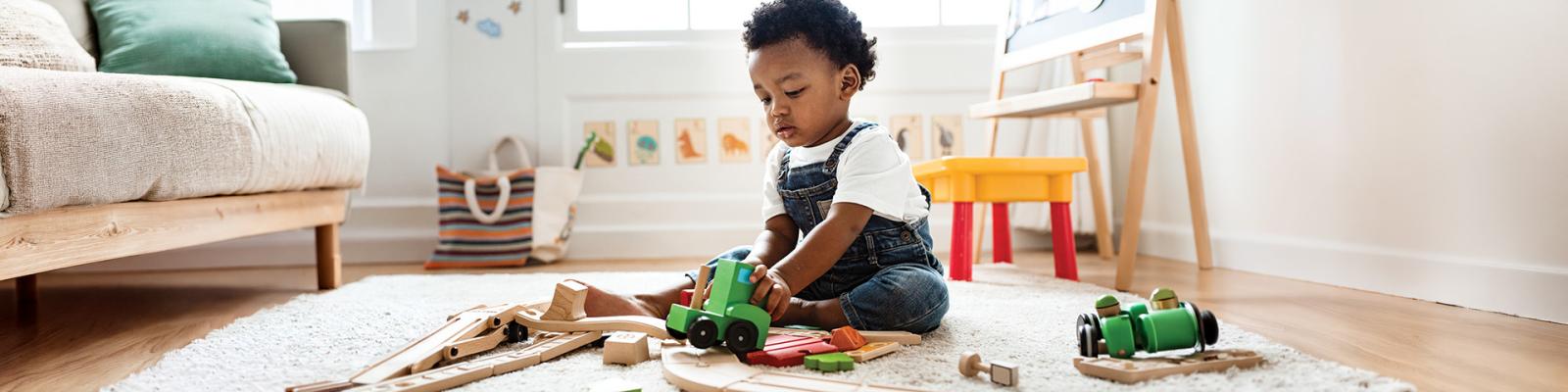 A small toddler plays in a room full of toys.